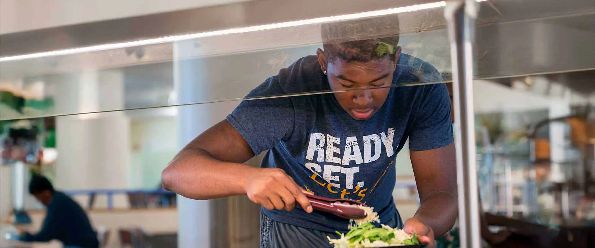 Student making salad at salad bar